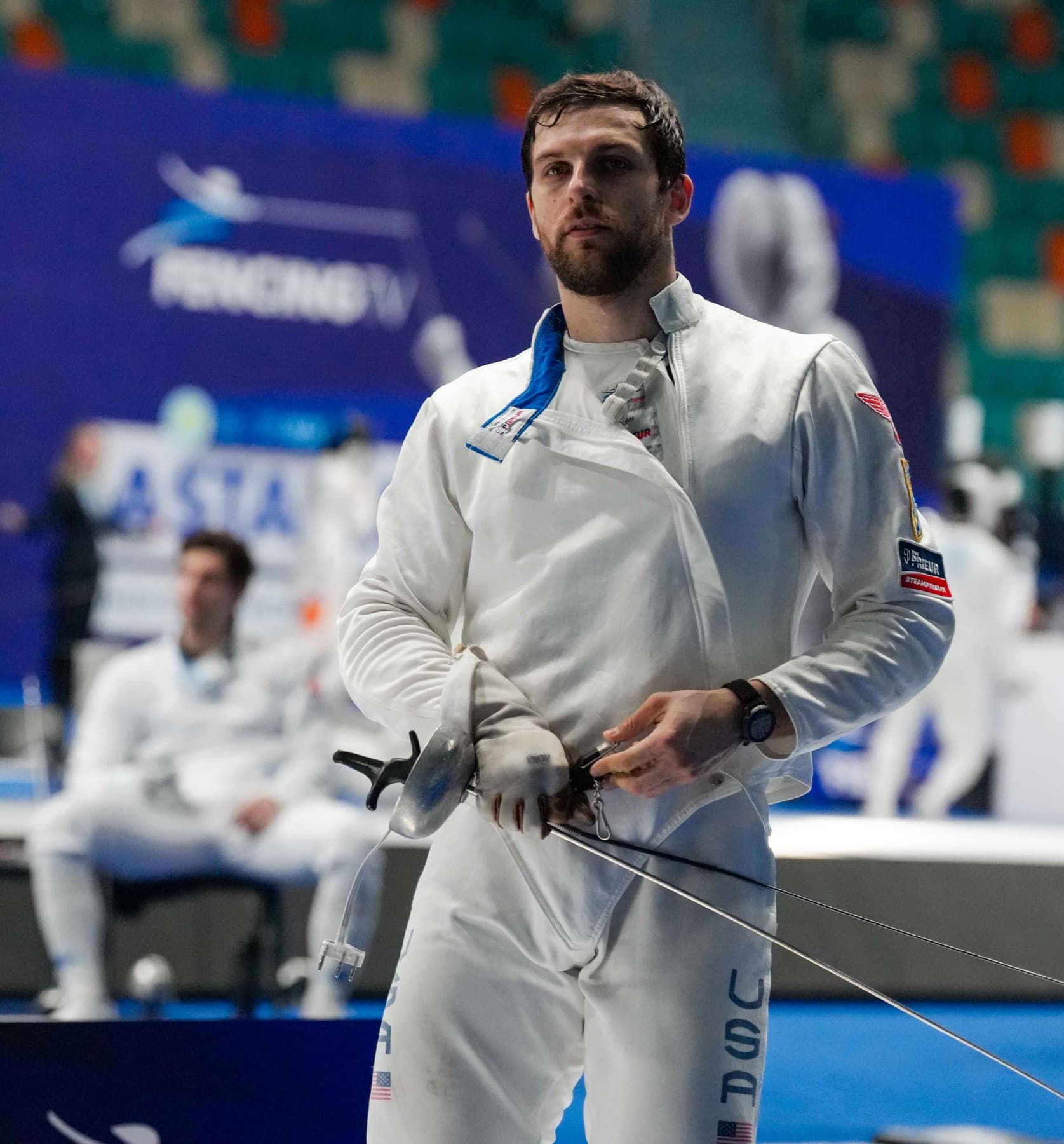 Ari in USA jacket holding épée at an international competition